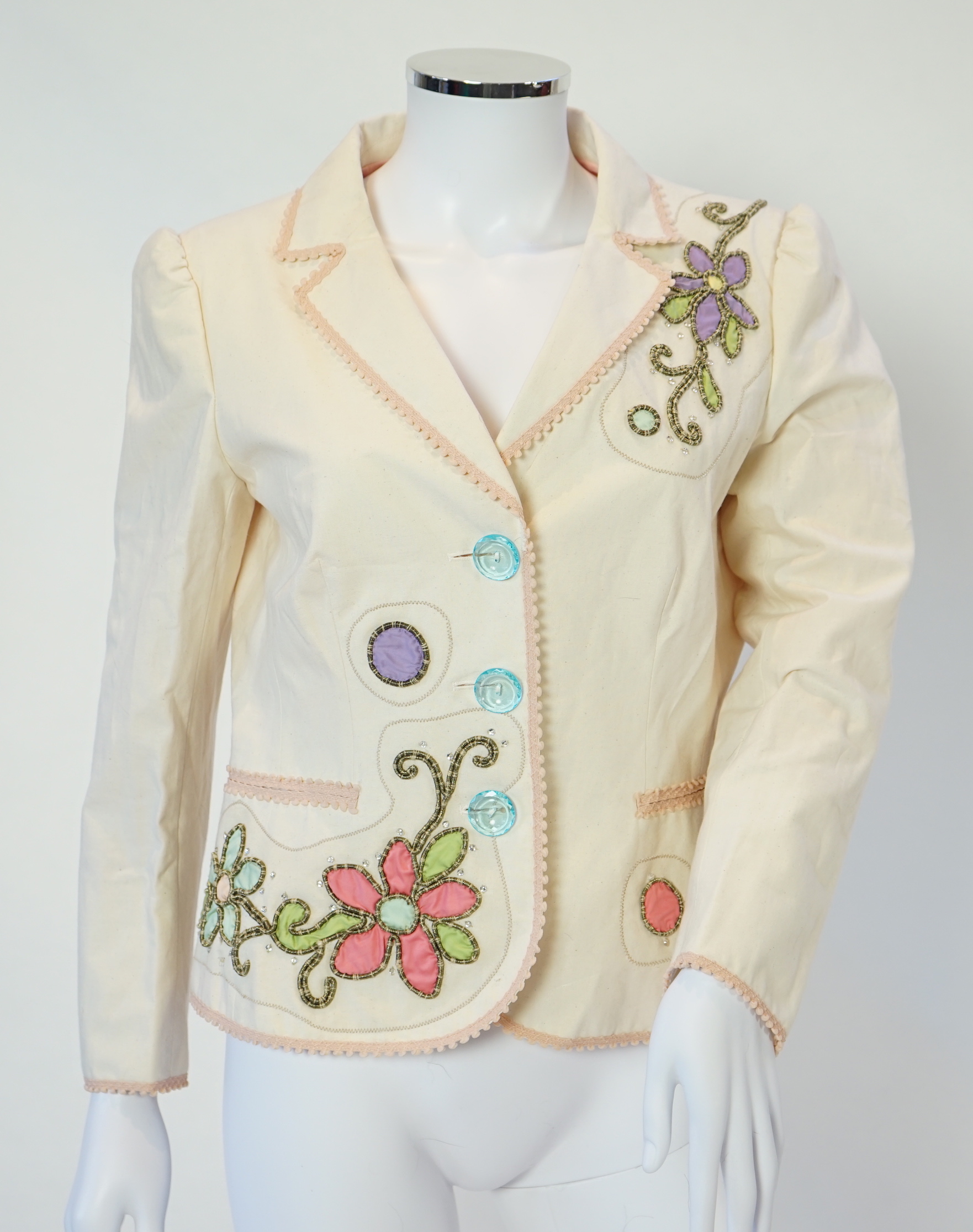 A Moschino lady's long blue and red jacket, a cream cotton embellished blazer and a cotton pair of floral trousers, blue and red jacket size 14, cream blazer size 12, trousers size: 10